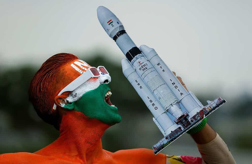 Arun Haryani, un passionné dont le corps est peint en tricolore, réagit le 22 août 2023 en brandissant un modèle de LVM3 M4 qui a été utilisé pour le lancement du vaisseau spatial Chandrayaan-3 à la veille de son atterrissage sur la lune. | Crédit photo : Reuters