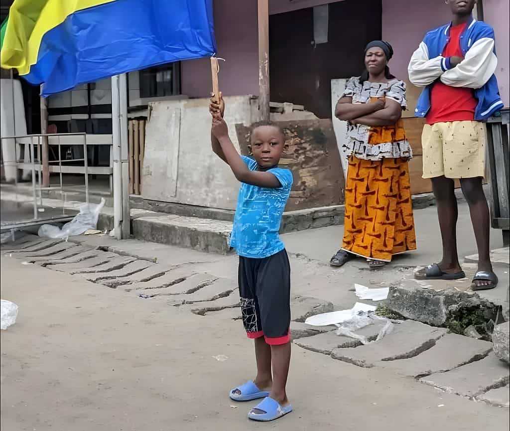 Un enfant portant un drapeau du Gabon dans les rues
