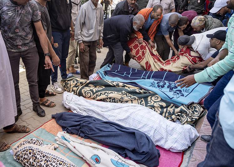 Des hommes alignent les corps des personnes tuées lors d'un tremblement de terre à Moulay Brahim, dans la province d'Al Haouz, le 9 septembre 2023.
(Photo par FADEL SENNA / AFP)