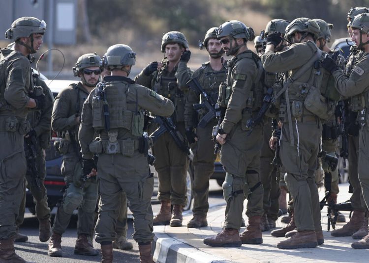 Des soldats israéliens se rassemblent sur la route dans le centre d'Israël le samedi 7 octobre 2023. (Photo AP/Ohad Zwigenberg)