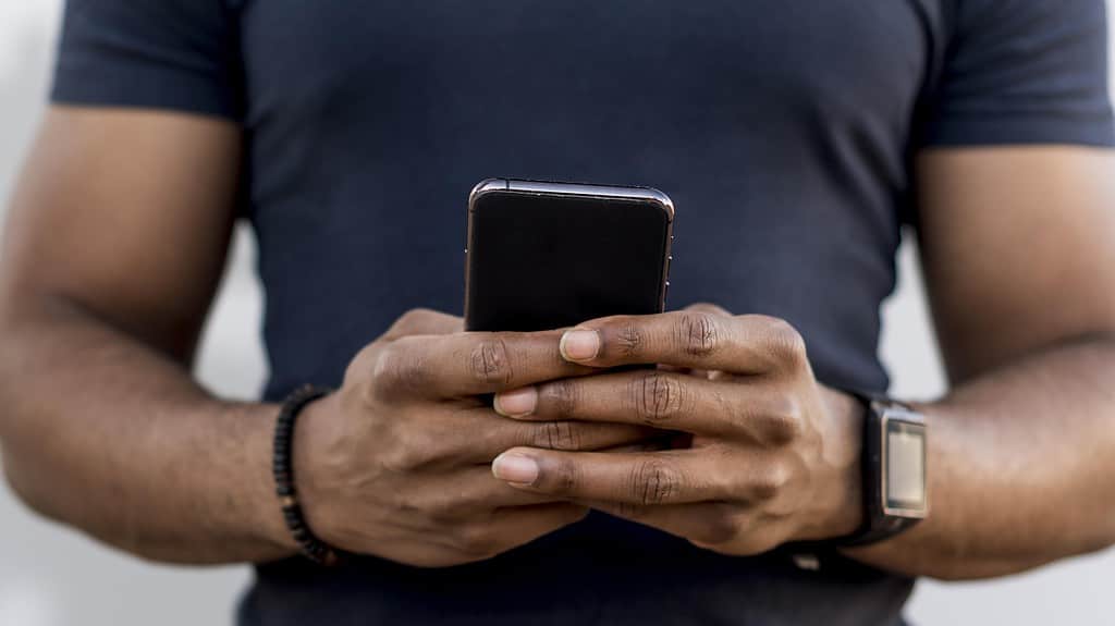 Un jeune homme tenant un smartphone