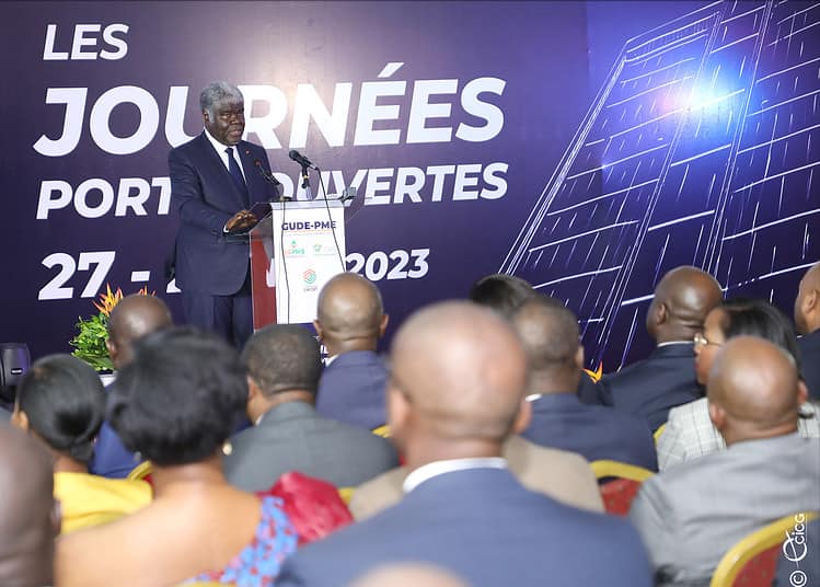 Stylish African American black businessman talks on his smartphone standing before a modern glass building outside