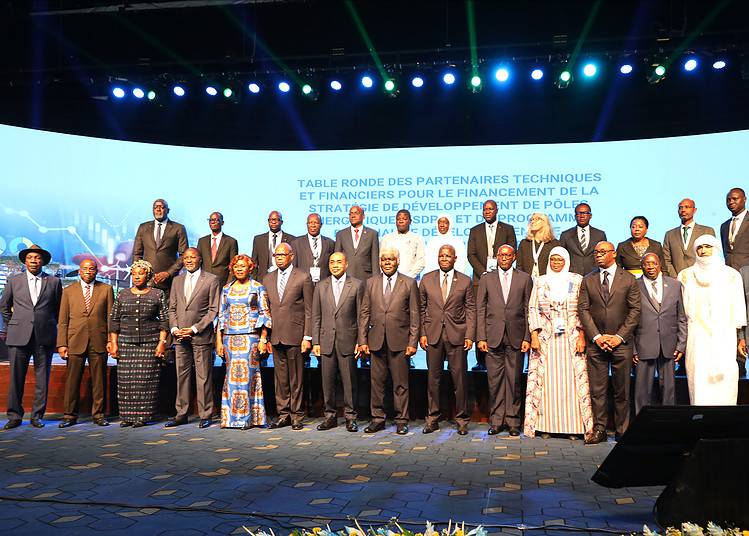 Stylish African American black businessman talks on his smartphone standing before a modern glass building outside