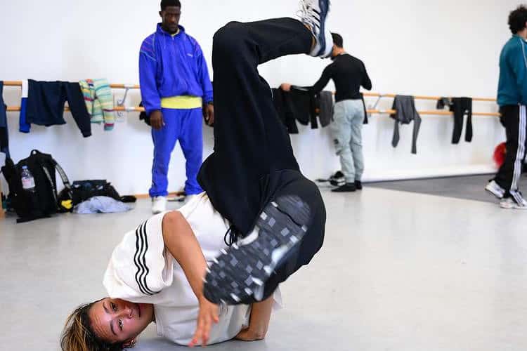 France's Bboy Danny Dan (L) and France's Bgirl Carlota Dudek (C) attend a breaking dance training session at the French National Institute of Sport (INSEP), in Paris on September 28, 2022. - Breaking will be present as an additional discipline at the 2024 Olympics Games in Paris. (Photo by Anne-Christine POUJOULAT / AFP)