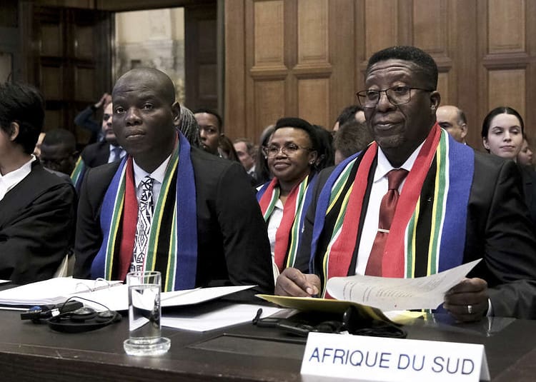 Ambassador of the Republic of South Africa to the Netherlands Vusimuzi Madonsela, right, and Minister of Justice and Correctional Services of South Africa Ronald Lamola, center, during the opening of the hearings at the International Court of Justice in The Hague, Netherlands, Thursday, Jan. 11, 2024. The United Nations' top court opens hearings Thursday into South Africa's allegation that Israel's war with Hamas amounts to genocide against Palestinians, a claim that Israel strongly denies. (AP Photo/Patrick Post)