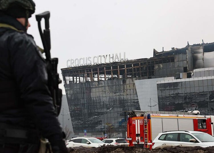 A law enforcement officer patrols the scene of the gun attack at the Crocus City Hall concert hall in Krasnogorsk, outside Moscow, on March 23, 2024. Gunmen who opened fire at a Moscow concert hall killed more than 60 people and wounded over 100 while sparking an inferno, authorities said on March 23, 2024, with the Islamic State group claiming responsibility. (Photo by STRINGER / AFP)