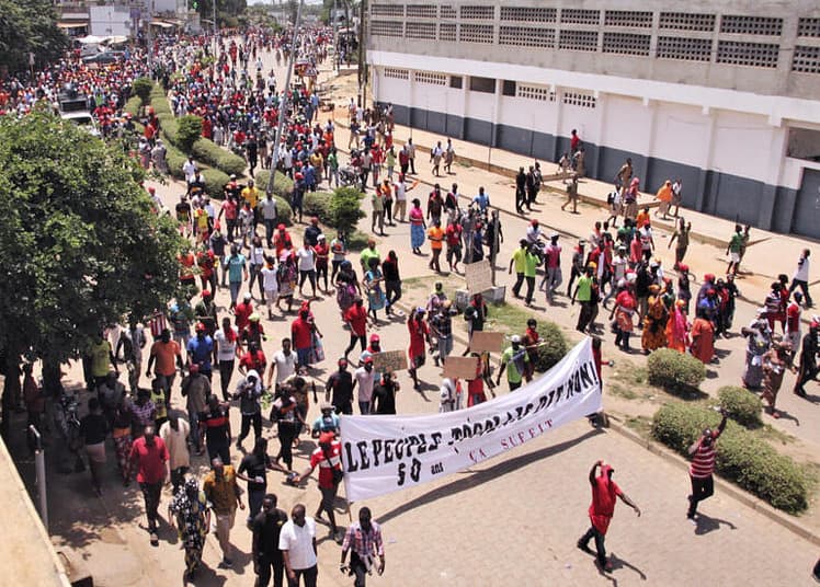 People walk behind a banner reading "The Togolese people say no! 50 years is enough." as thousands of protestors march through the streets of Lome on October 5, 2017, during a demonstration against Togolese President.
Demonstrators converged from three points in the capital Lome for what was billed as a "march of anger" against a family which has ruled Togo for 50 years, culminating in a rally on the seafront. / AFP PHOTO / MATTEO FRASCHINI KOFFI