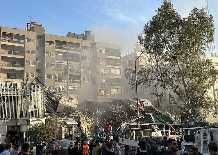 Emergency and security personnel gather at the site of strikes which hit a building adjacent to the Iranian embassy in Syria's cpital Damascus, on April 1, 2024. Israeli strikes hit Syria's capital on April 1, state media reported, as a war monitor said six people were killed in a building adjacent to the Iranian embassy. (Photo by Maher AL MOUNES / AFP)