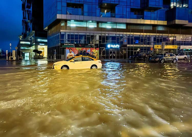 TOPSHOT - A taxi drives through a flooded street following heavy rains in Dubai early on April 17, 2024. (Photo by Giuseppe CACACE / AFP)