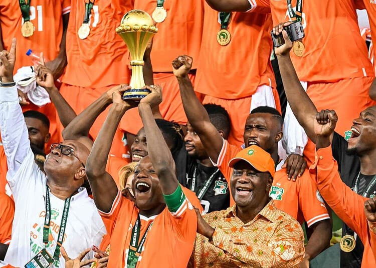 Ivory Coast's forward #15 Max-Alain Gradel (C) lifts the Africa Cup of Nations trophy on the podium after Ivory Coast won the Africa Cup of Nations (CAN) 2024 final football match between Ivory Coast and Nigeria at Alassane Ouattara Olympic Stadium in Ebimpe, Abidjan on February 11, 2024. (Photo by Sia KAMBOU / AFP)