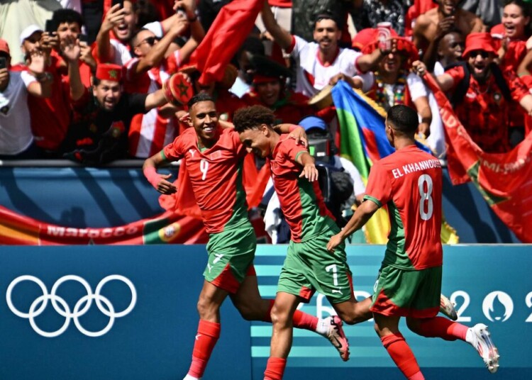 Morocco's forward #09 Soufiane Rahimi (L) celebrates with Morocco's forward #07 Eliesse Ben Seghir (C) and Morocco's midfielder #08 Bilal El Khannouss after scoring a penalty and his team's second goal in the men's group B football match between Argentina and Morocco during the Paris 2024 Olympic Games at the Geoffroy-Guichard Stadium in Saint-Etienne on July 24, 2024. (Photo by Arnaud FINISTRE / AFP)