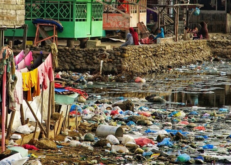 (FILES) This picture shows rubbish washed ashore next to homes beside a river mouth at a coastal village in Lhokseumawe, Indonesia's Aceh province on June 3, 2021. Negotiations on a global treaty to combat plastic pollution will resume on May 29, 2023, with nations under pressure to stem the tide of trash amid calls from campaigners to limit industry influence on the talks. Some 175 nations pledged last year to agree by 2024 a binding deal to end the pollution from largely fossil fuel-based plastics that is choking the environment and infiltrating the bodies of humans and animals. The May 29-June 2 talks in Paris are tasked with agreeing the first outline for actions that could form the basis of a draft negotiating text. (Photo by Azwar Ipank / AFP) / TO GO WITH Pakistan-environment-plastic,FEATURE by Joris Fioriti