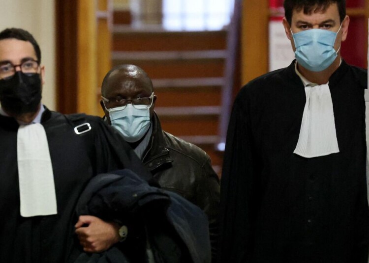 Franco-Rwandan former hotel driver Claude Muhayimana (C) arrives at the Paris courthouse for his trial, in which he is accused of complicity in Rwanda's 1994 genocide by transporting Hutu militiamen who massacred hundreds of Tutsis, on November 22, 2021. - Claude Muhayimana, who investigators say also hid Tutsis at risk of death and helped some escape, fled after the genocide and gained French nationality in 2010. He faces a life sentence if convicted. (Photo by Thomas COEX / AFP)