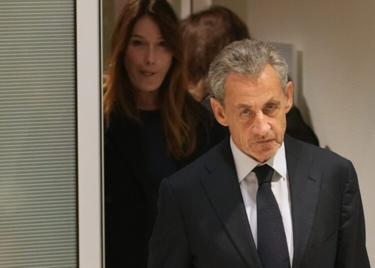 Former French President Nicolas Sarkozy and his wife Carla leave after a Paris court sentenced him to 5 years after finding him guilty of criminal conspiracy in an alleged scheme to finance his 2007 campaign with funds from Libya, Thursday, Sept. 25, 2025 in Paris. (AP Photo/Christophe Ena)
