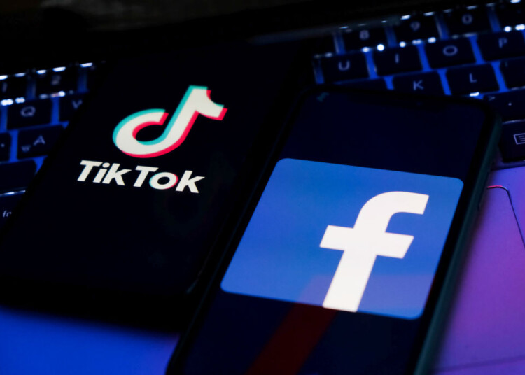 TikTok and Facebook logos displayed on phone screens and a laptop keyboard are seen in this illustration photo taken in Krakow, Poland on February 6, 2022. (Photo illustration by Jakub Porzycki/NurPhoto via Getty Images)
