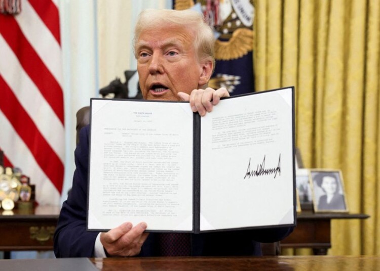 U.S. President Donald Trump holds a signed executive order in the Oval Office of the White House, in Washington, U.S., January 23, 2025. REUTERS/Kevin Lamarque